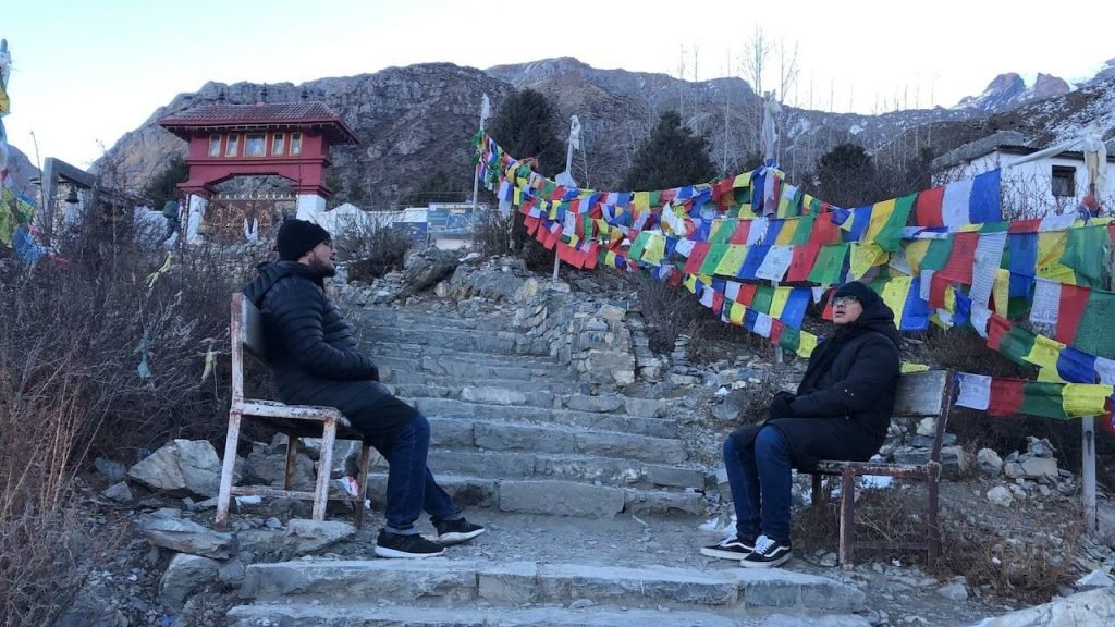 Two visitors resting on the bench at muktinath