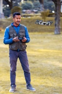 Professional travel photographer Chandra Man Dongol operating a drone in Nepal's landscape