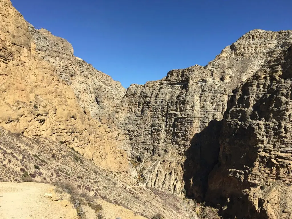 A rugged canyon landscape with towering rock formations on the way to Syanbochen in the Upper Mustang region of Nepal.