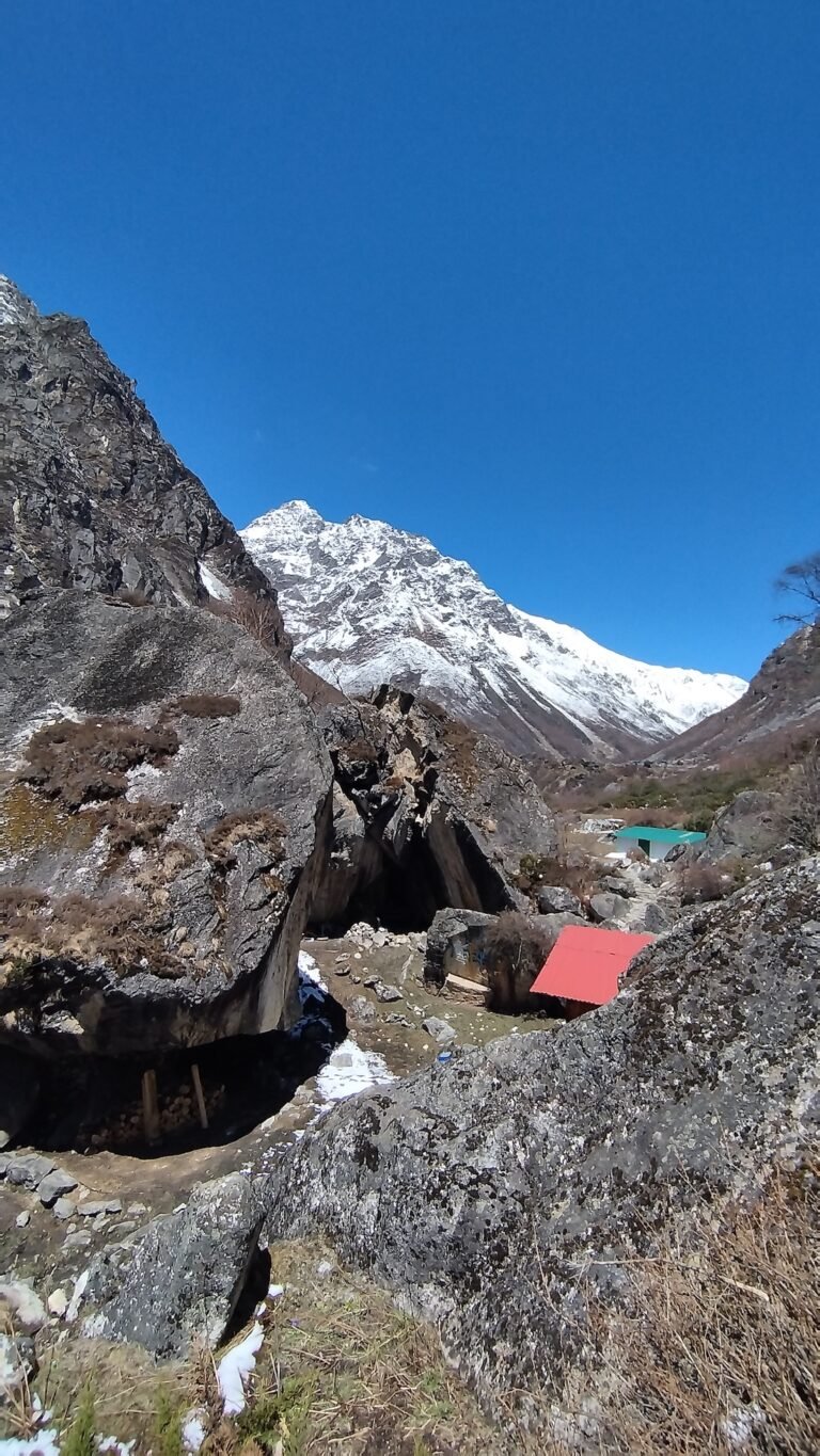 Snow-capped Himalayan peaks and mountain huts in Lapchi valley under a clear blue sky