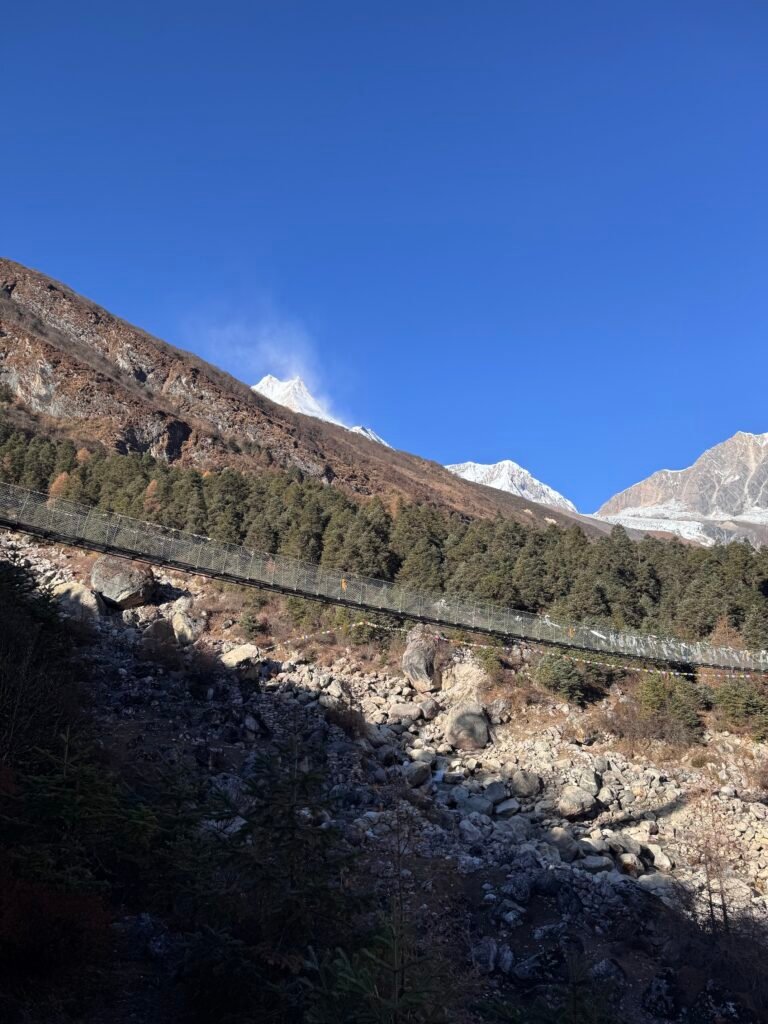 Suspension bridge with prayer flags over rocky gorge near Samagaun on the Manaslu Circuit trek